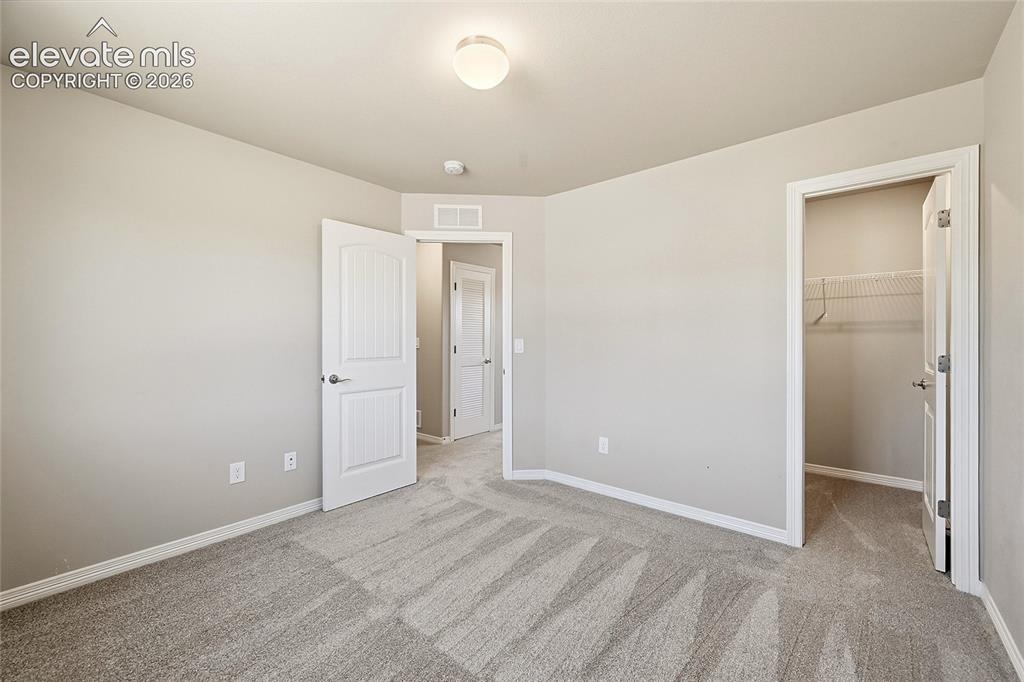 Image 22 of 30: Neutral-toned interior room featuring light gray walls, plush patterned car