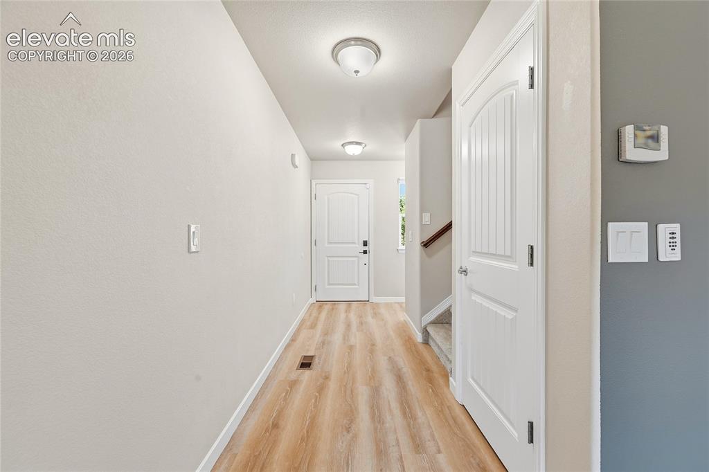 Image 6 of 30: Entryway featuring wood-finish flooring, light neutral wall tones, and whit