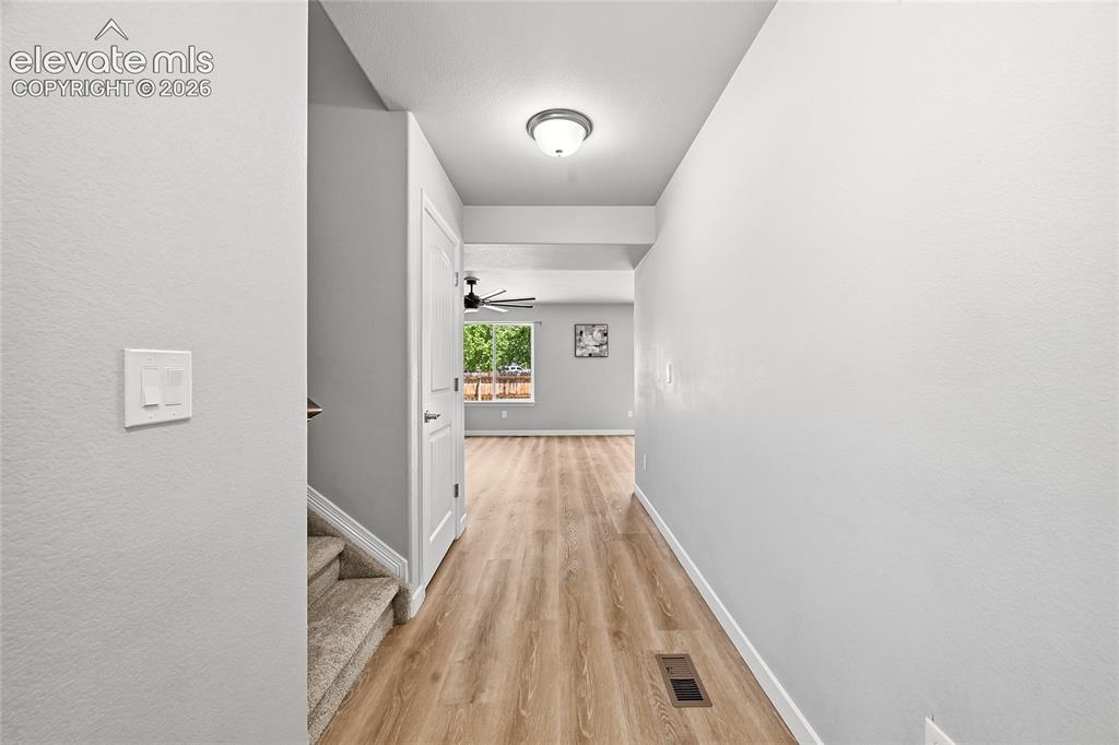 Image 8 of 30: Hallway featuring wood-finish flooring, a ceiling-mounted light fixture, an