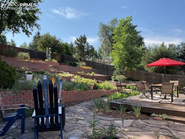 Image 6 of 48: Backyard flagstone, composite deck, terraced yard
