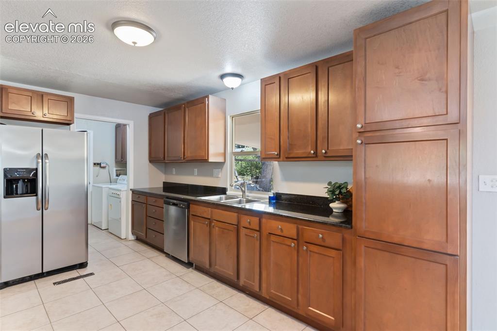 Image 20 of 21: Spacious kitchen with tile floors and granite countertops. Perfect for the 