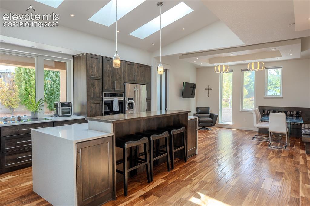 Image 7 of 50: This kitchen has it all. Custom cabinetry, waterfall quartz counters, bar s