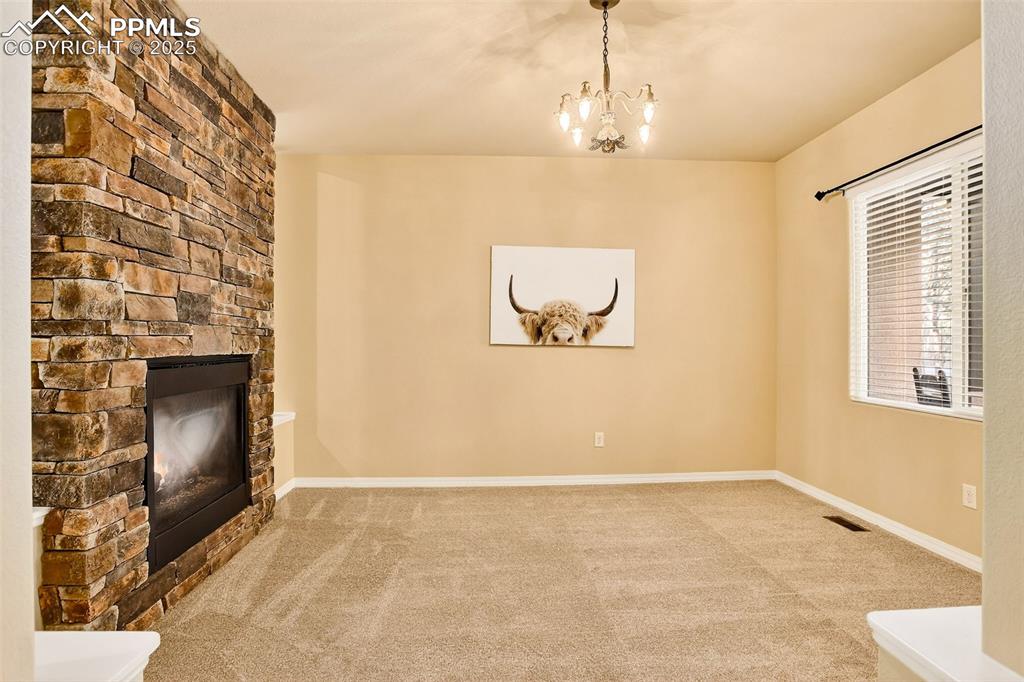 Image 14 of 45: Formal Dining room with a fireplace,  new carpet, and a chandelier