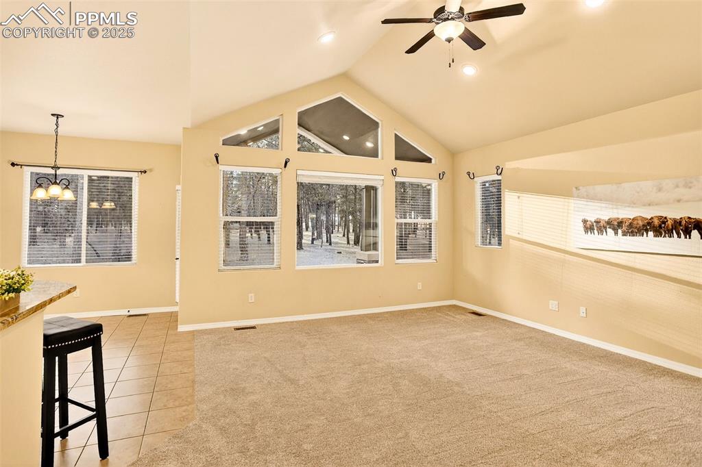 Image 22 of 45: Great Room with transom windows overlooking the 2.55 acre property featurin