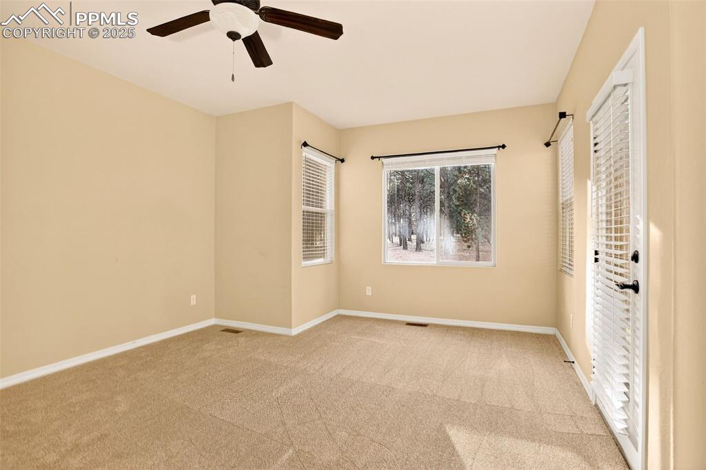Image 25 of 45: Primary  bedroom featuring light colored carpet and a ceiling fan and sitti