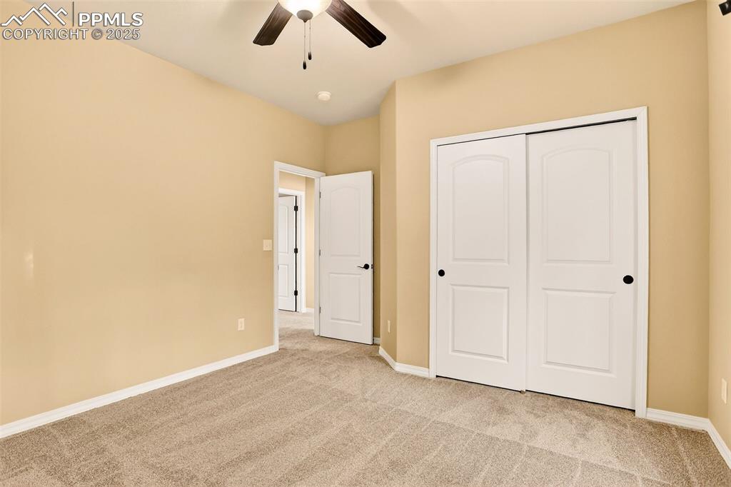 Image 28 of 45: Third bedroom featuring light colored carpet, a closet, and ceiling fan