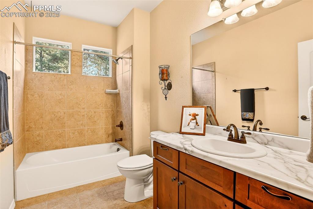 Image 29 of 45: Full bathroom featuring shower / bath combination, vanity, and light tile p