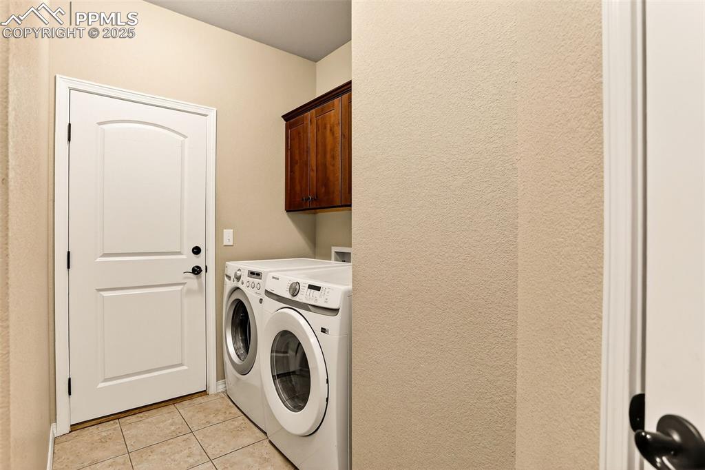 Image 30 of 45: Laundry room with light tile patterned floors, separate washer and dryer, a