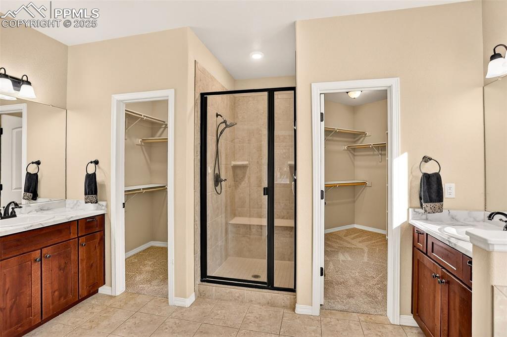 Image 36 of 45: Full bath with a spacious closet, vanity, light tile patterned flooring, an