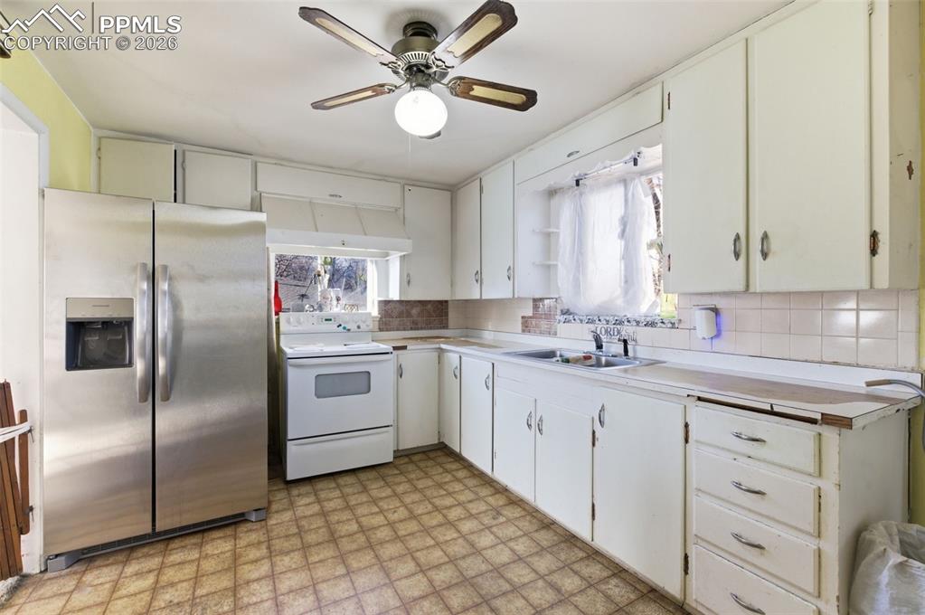 Image 11 of 35: Kitchen featuring stainless steel fridge, light flooring, white electric st