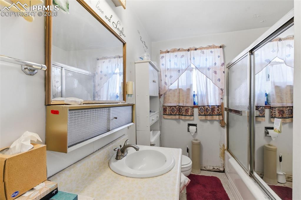 Image 20 of 35: Full bath featuring vanity and bath / shower combo with glass door