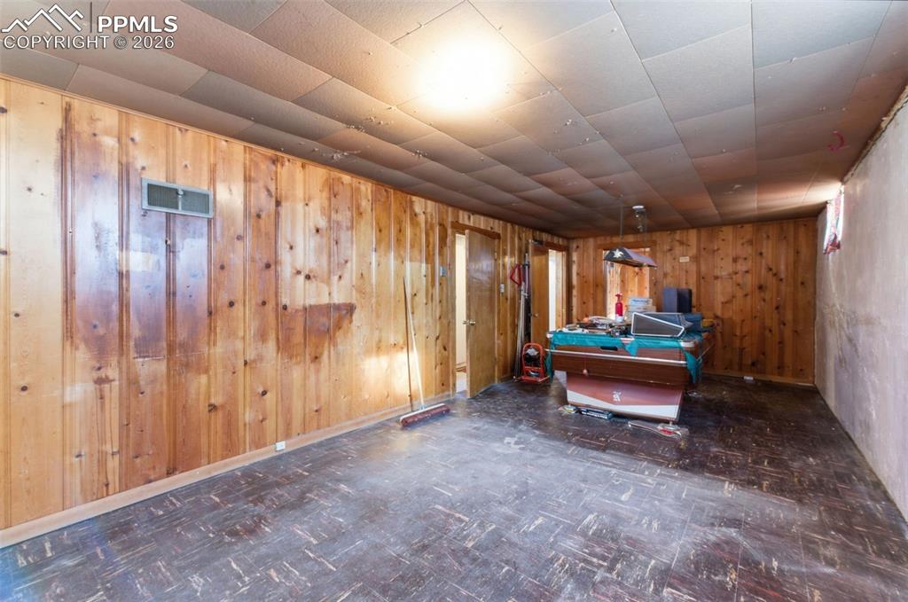 Image 26 of 35: Game room with tile patterned floors, pool table, and wooden walls