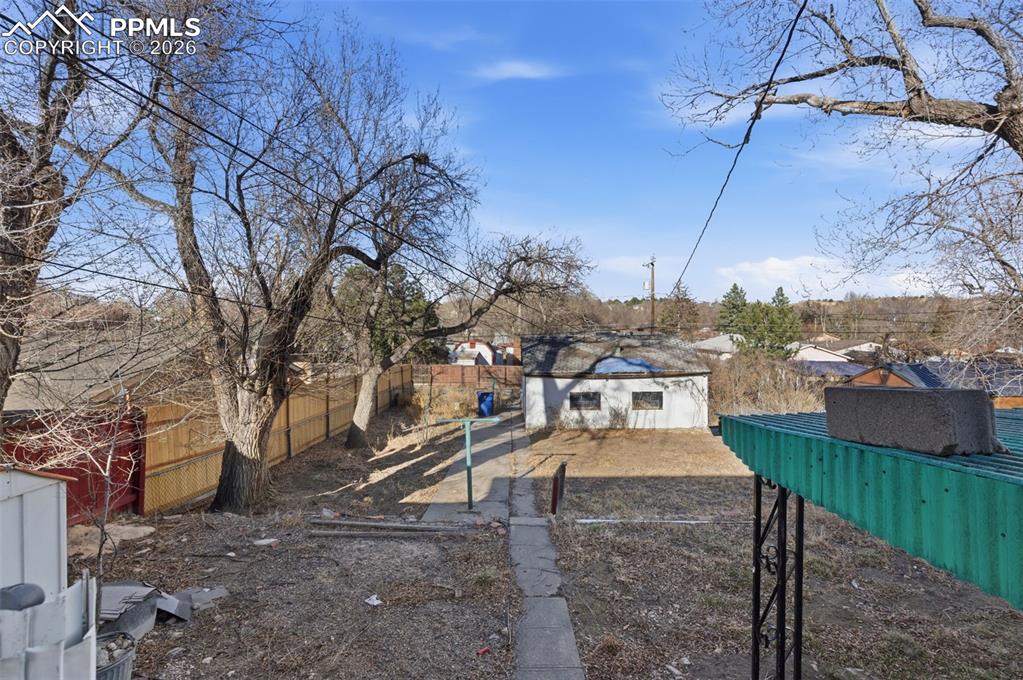 Image 35 of 35: Fenced backyard with an outbuilding