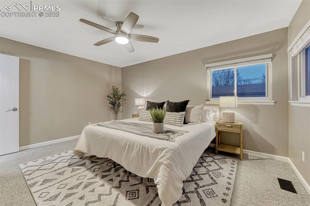 Image 24 of 49: Primary bedroom with ceiling fan is so spacious