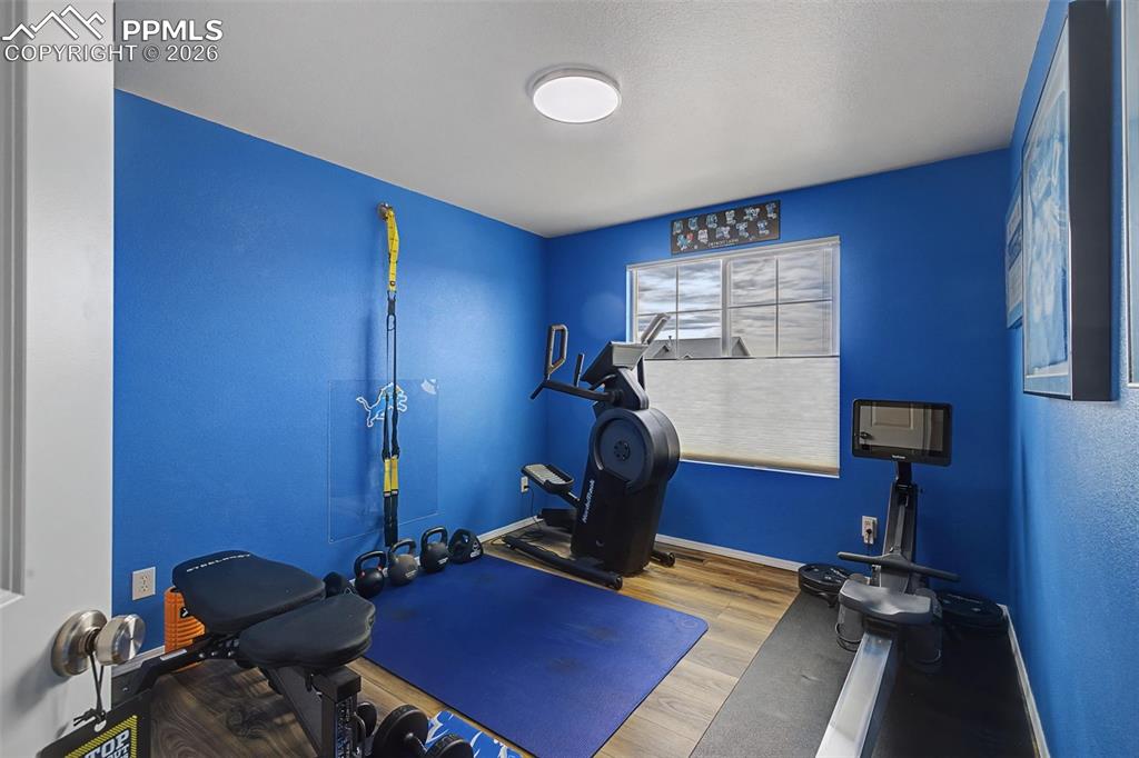 Image 28 of 50: Upstairs additional bedroom being used as a workout area.