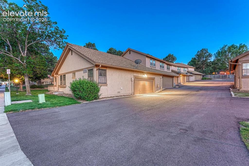 Image 12 of 48: Rear view of complex with 2-car attached garage.