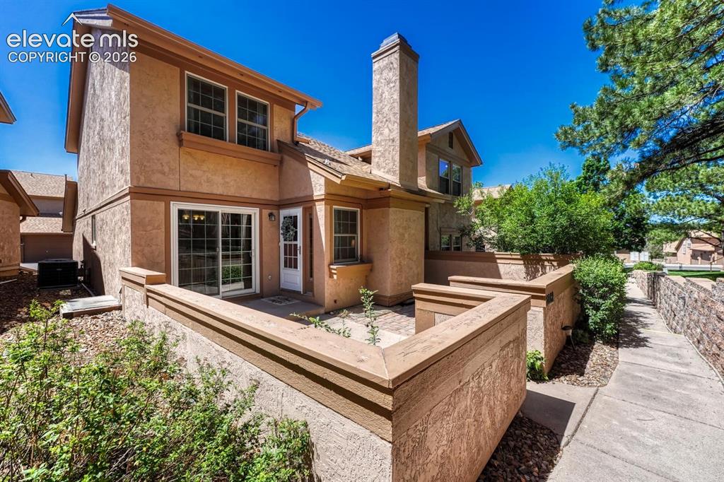 Image 13 of 48: Front of home with enclosed courtyard, surrounded by peaceful, lush green s