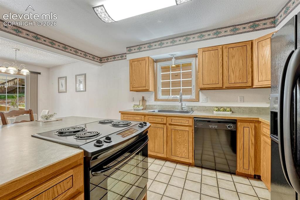 Image 23 of 48: Appliances include an electric range oven, dishwasher, and side by side ref