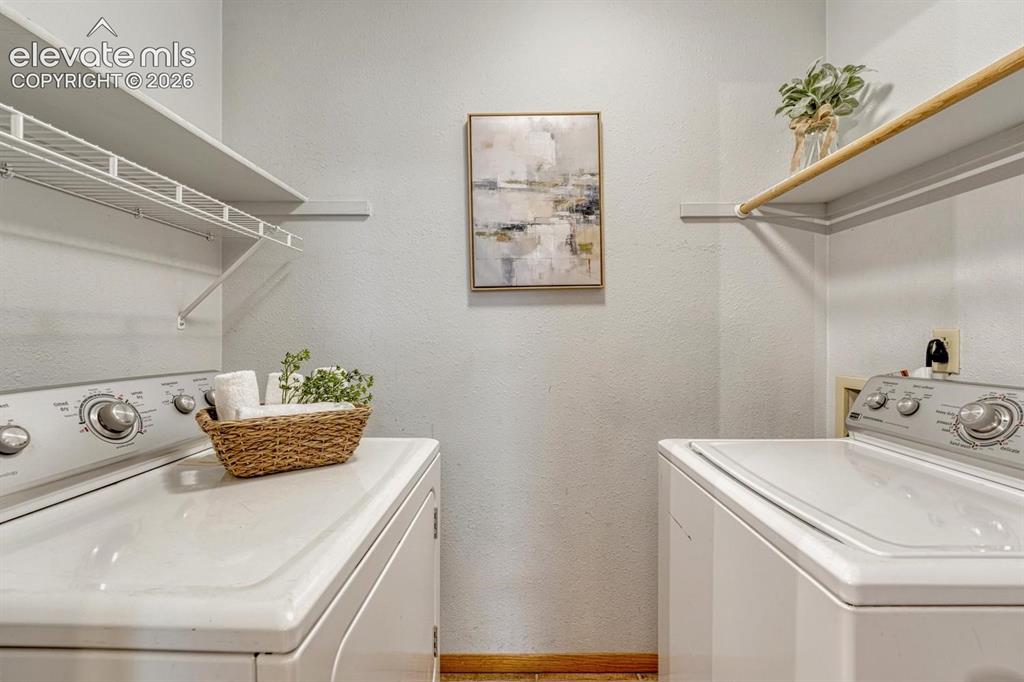 Image 26 of 48: Laundry room with tile flooring, built in shelves, and washer/dryer include