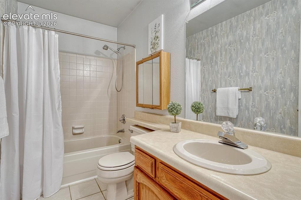 Image 30 of 48: Upper level full bathroom with vanity, mirror, and tub/shower.
