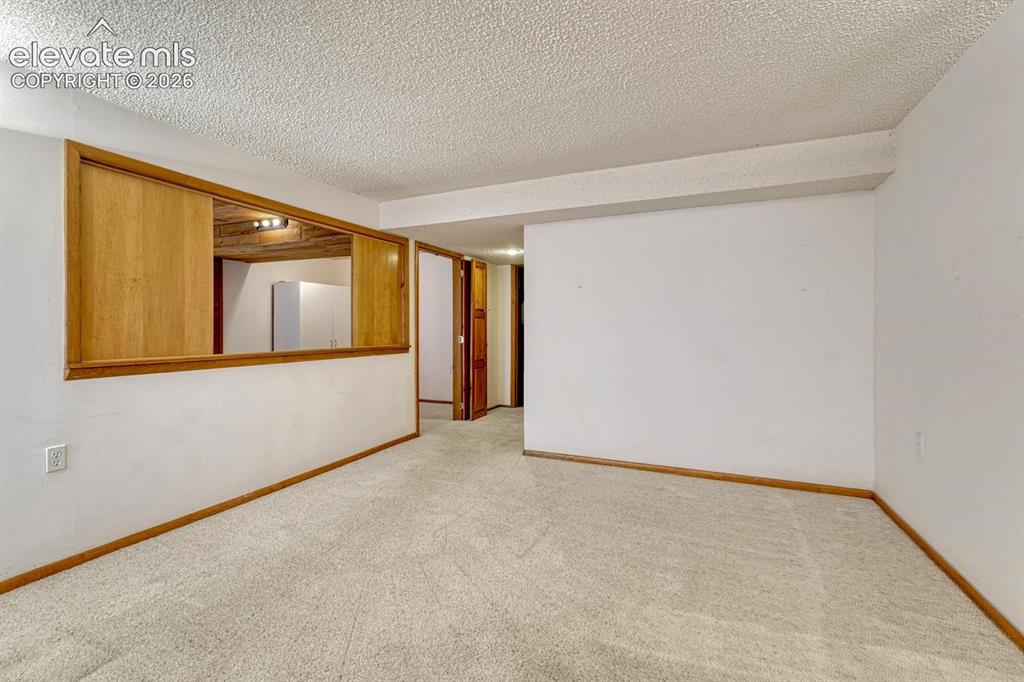 Image 37 of 48: Basement family room with pass through into the basement bedroom and entire