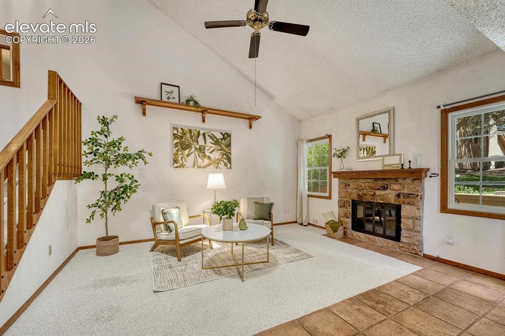 Image 4 of 48: Bright, inviting vaulted living room featuring neutral carpeting, a ceiling