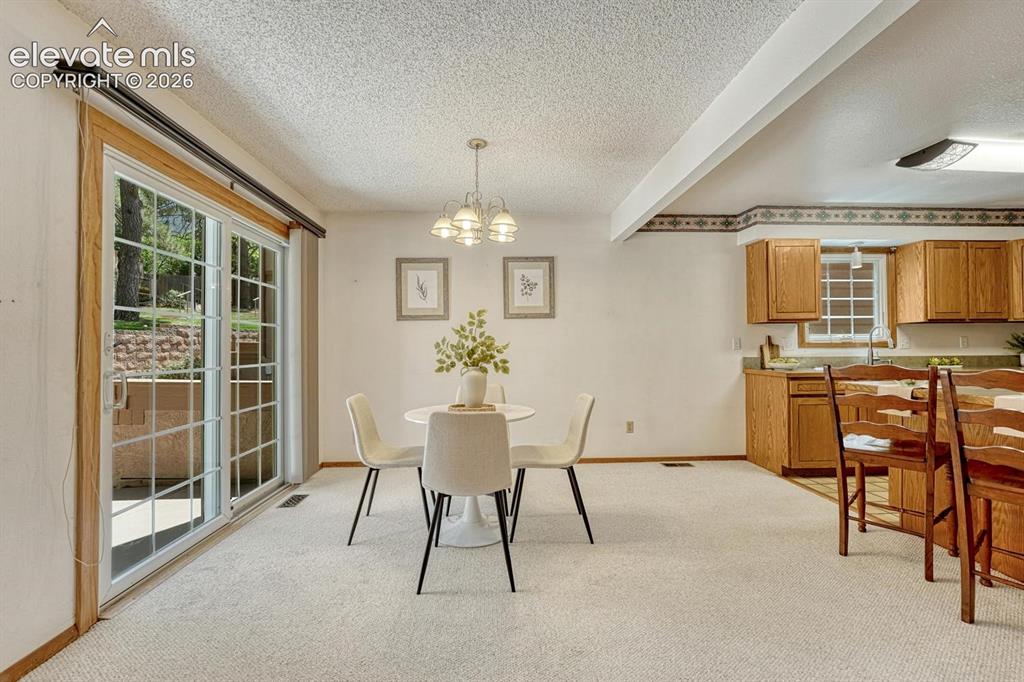 Image 5 of 48: The dining area provides indoor-outdoor living with a wood-framed sliding g