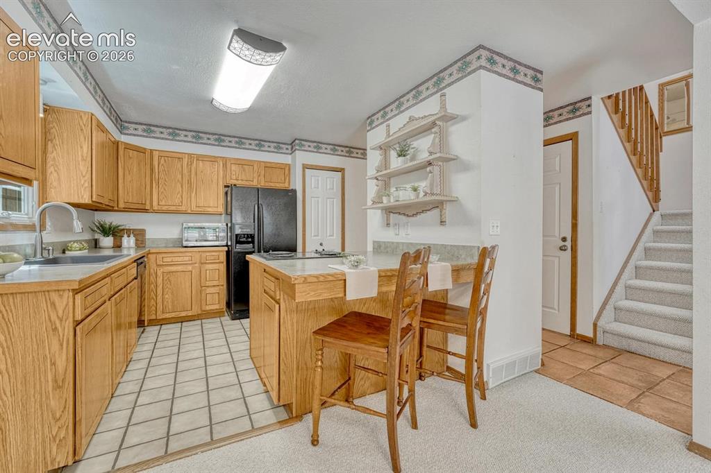 Image 6 of 48: The cheerful kitchen features oak cabinetry, generous counter space, custom