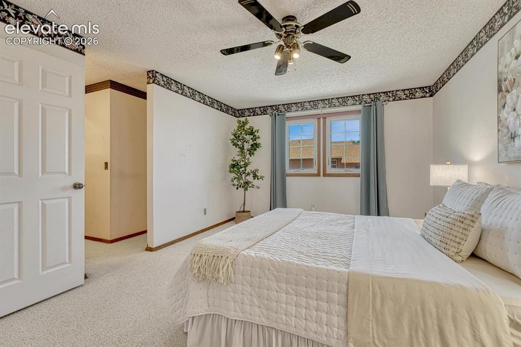 Image 9 of 48: The spacious primary suite features a lighted ceiling fan, walk-in closet,