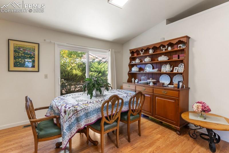 Image 22 of 29: Dining room featuring vaulted ceiling and light wood-style floors