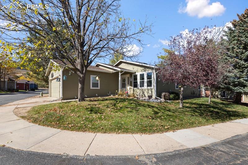 Image 3 of 29: View of front of property featuring a front lawn, an attached garage, and d