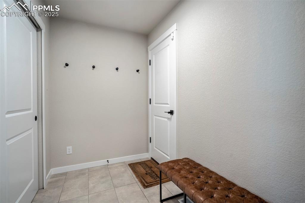Image 13 of 47: Mudroom with light tile patterned floors and baseboards