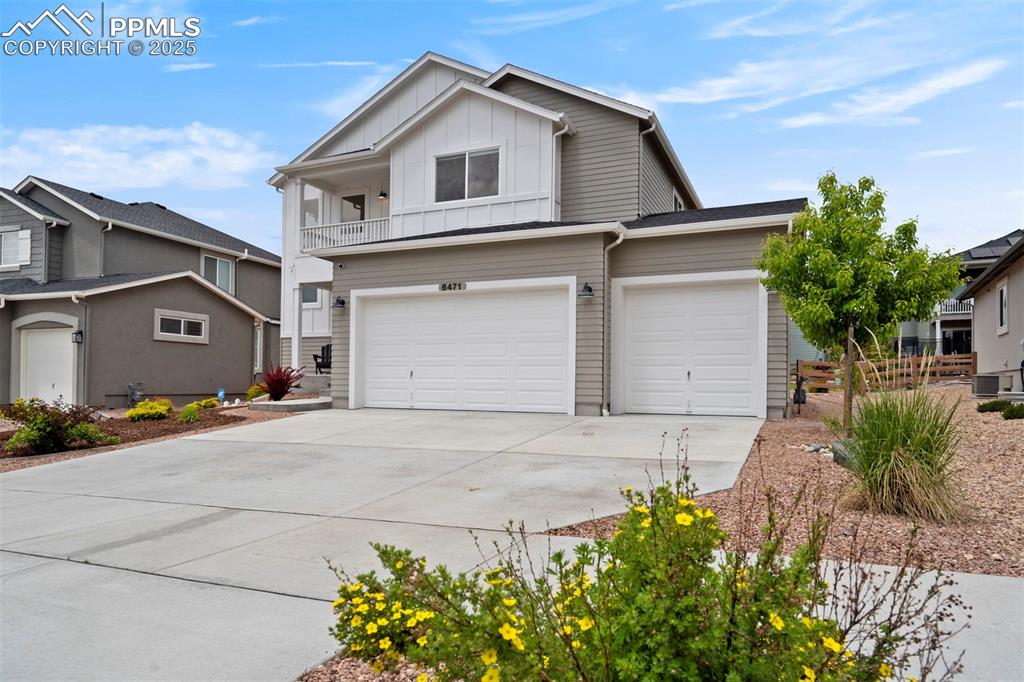 Image 2 of 47: View of front of home with board and batten siding, driveway, an attached g