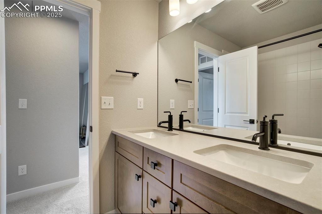 Image 25 of 47: Full bathroom with double vanity and baseboards
