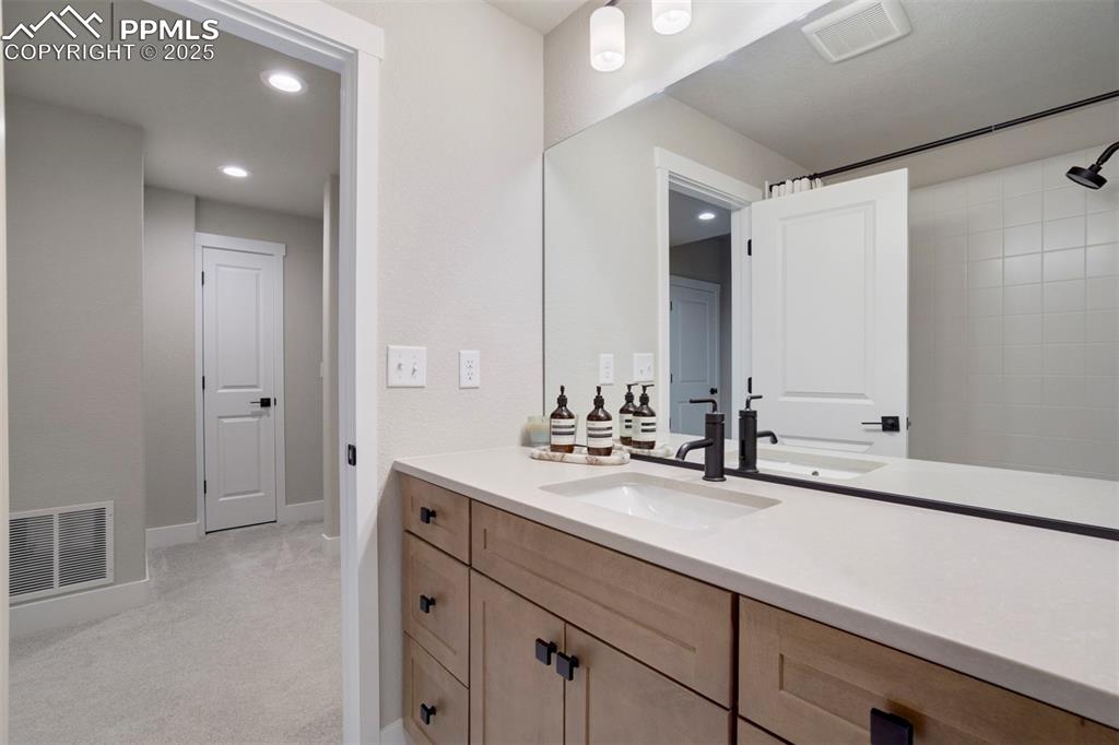 Image 36 of 47: Bathroom featuring vanity, baseboards, recessed lighting, and a shower