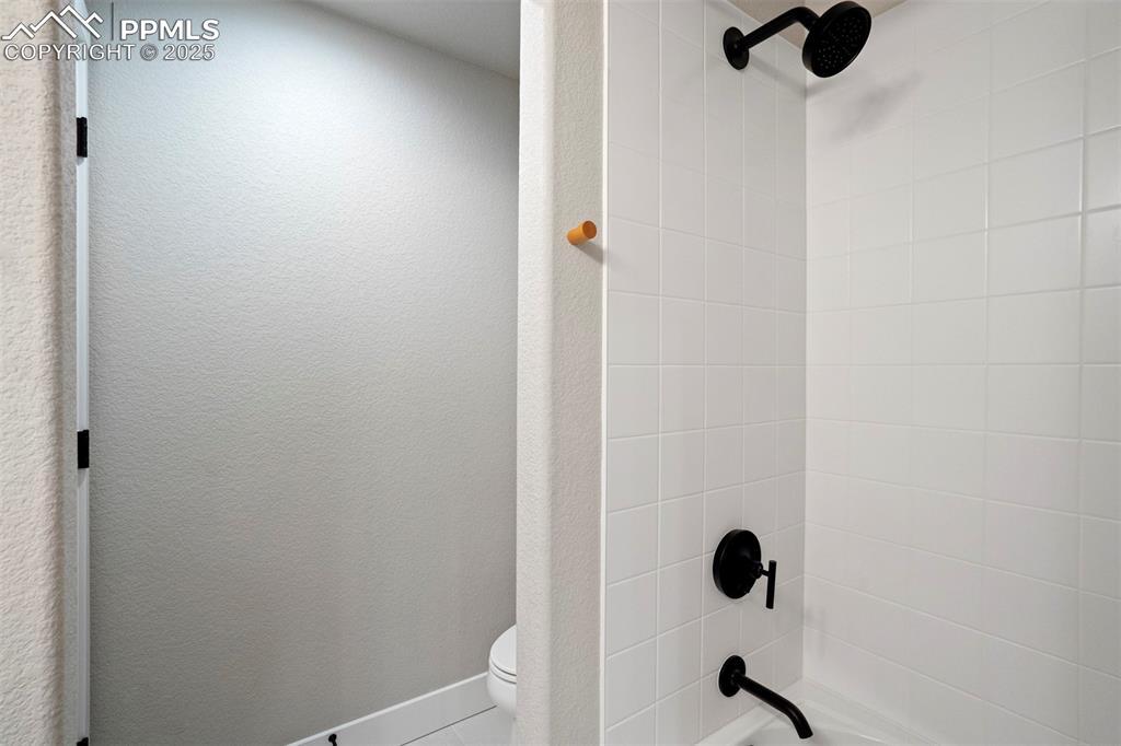 Image 37 of 47: Bathroom featuring washtub / shower combination and toilet