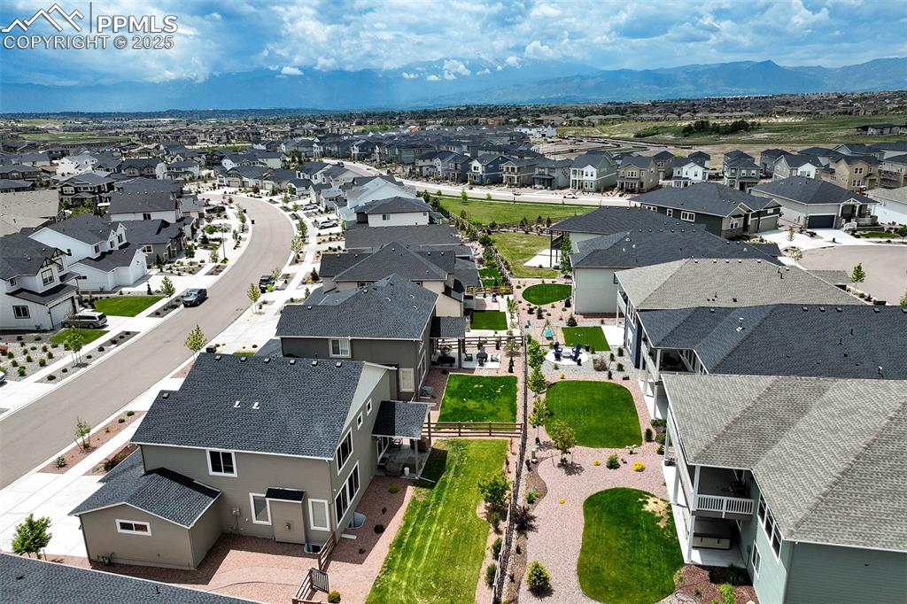 Image 43 of 47: Aerial view of residential area featuring a mountainous background
