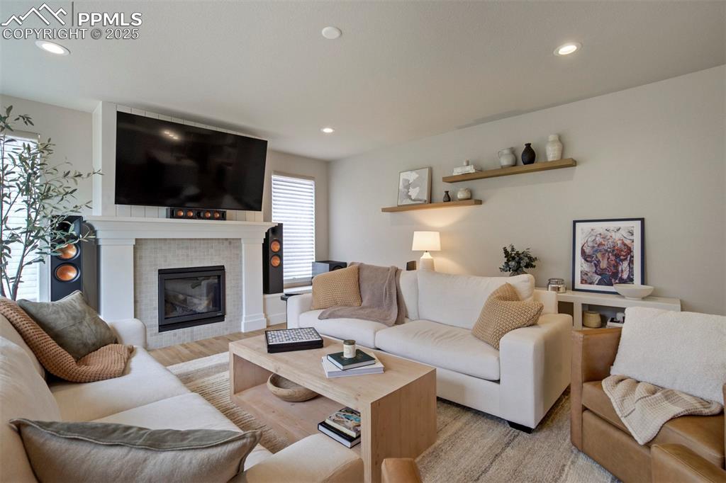 Image 6 of 47: Living room featuring recessed lighting, a tile fireplace, and light wood f