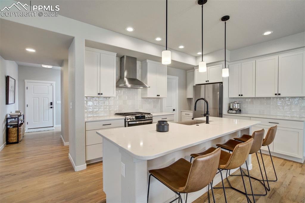 Image 9 of 47: Kitchen featuring wall chimney exhaust hood, appliances with stainless stee