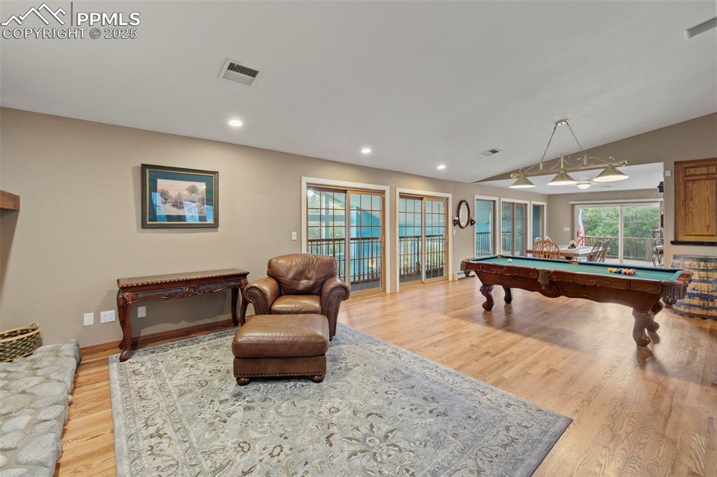 Image 13 of 50: Playroom with pool table, light wood-type flooring, vaulted ceiling, and re