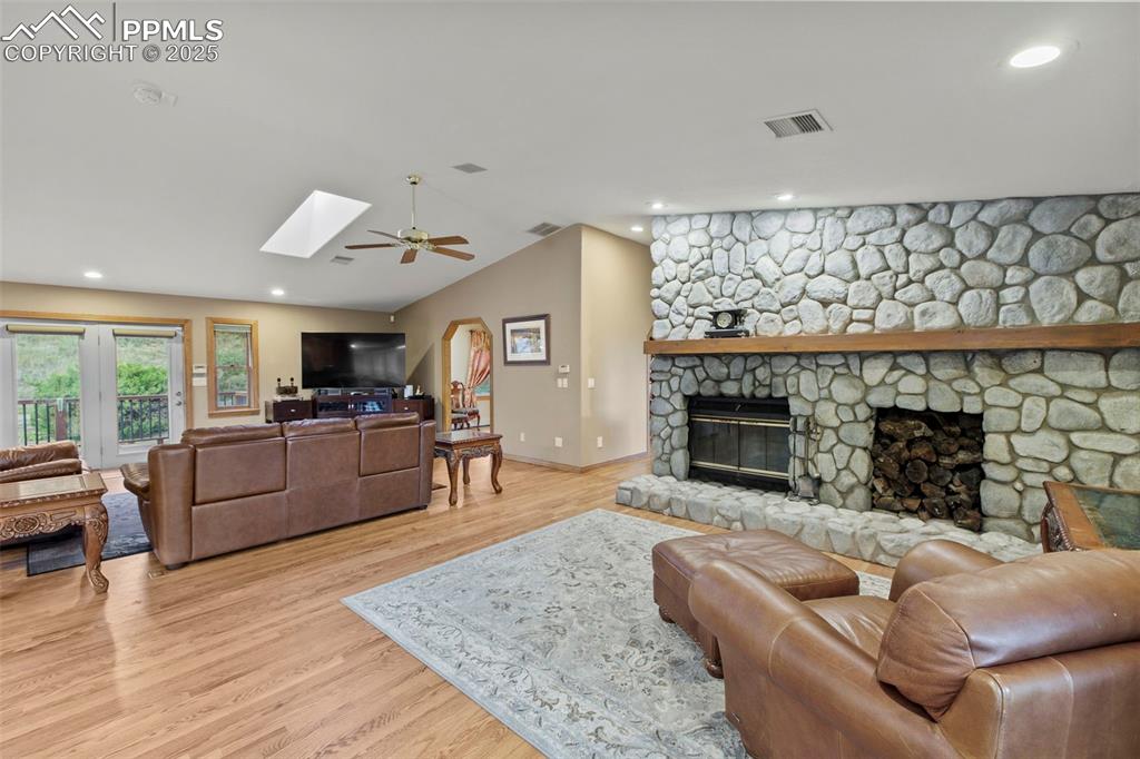 Image 14 of 50: Living area with lofted ceiling, a fireplace, recessed lighting, light wood