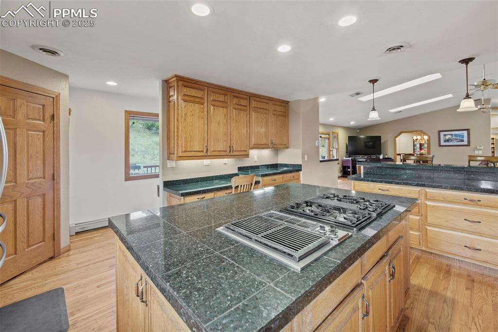 Image 20 of 50: Kitchen featuring decorative light fixtures, light wood finished floors, a 