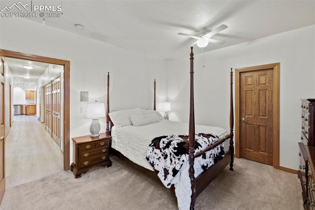 Image 29 of 50: Bedroom featuring ceiling fan, light carpet, and a textured ceiling