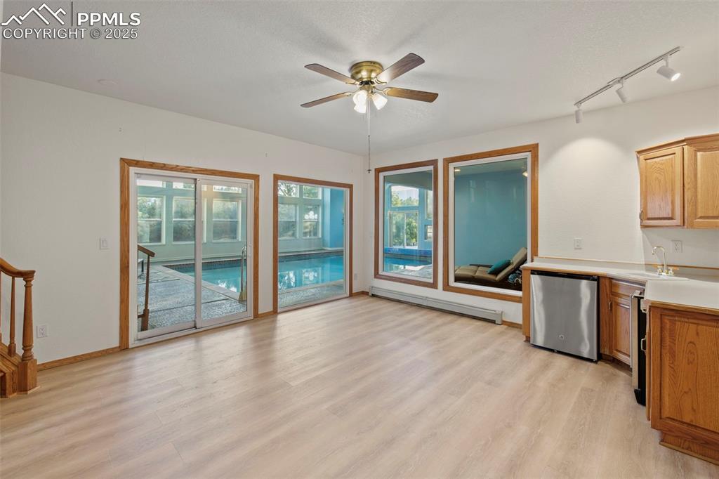 Image 37 of 50: Kitchen with light countertops, light wood-style flooring, baseboard heatin