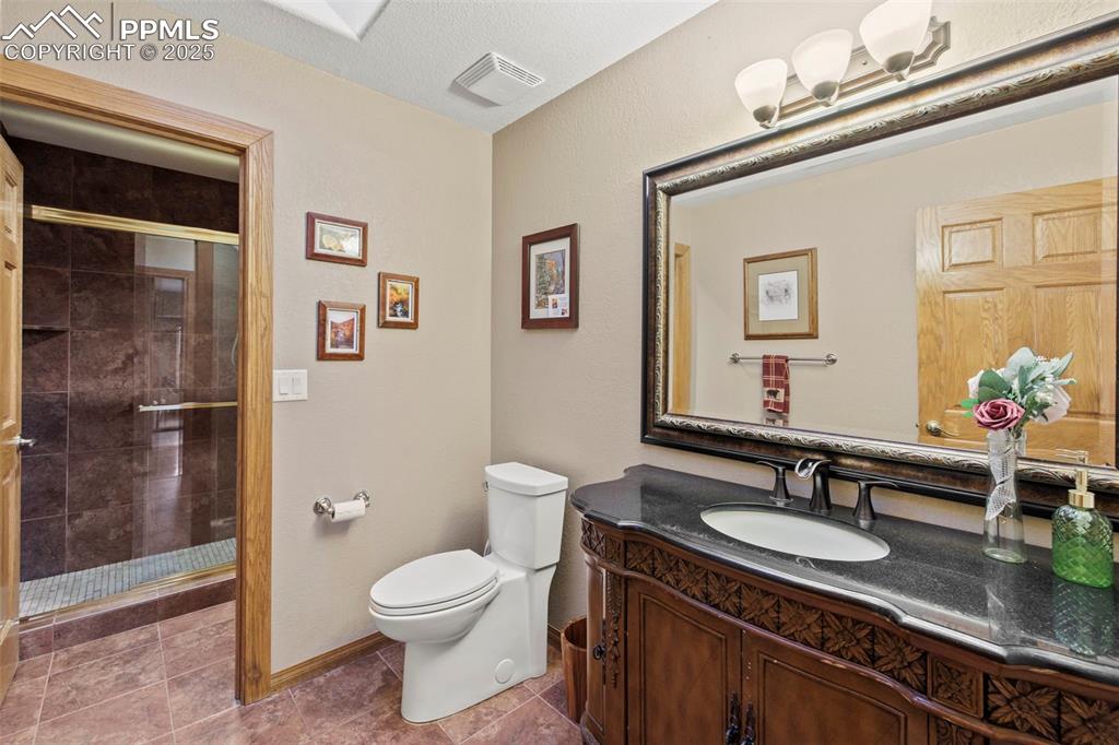 Image 9 of 50: Bathroom featuring a stall shower, vanity, and light tile patterned floors