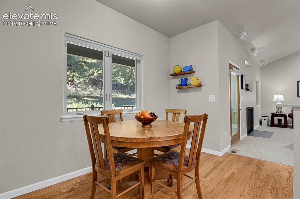 Image 11 of 46: Wood-finish flooring, vaulted ceilings, and natural light from a dual-pane