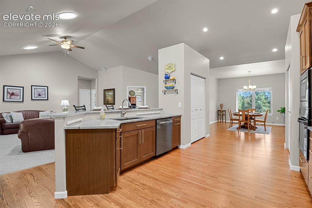 Image 13 of 46: Kitchen featuring wood cabinetry, stone countertops, stainless steel dishwa