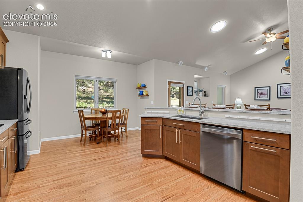 Image 14 of 46: Kitchen featuring wood-finish cabinetry, stone-surface countertops, stainle