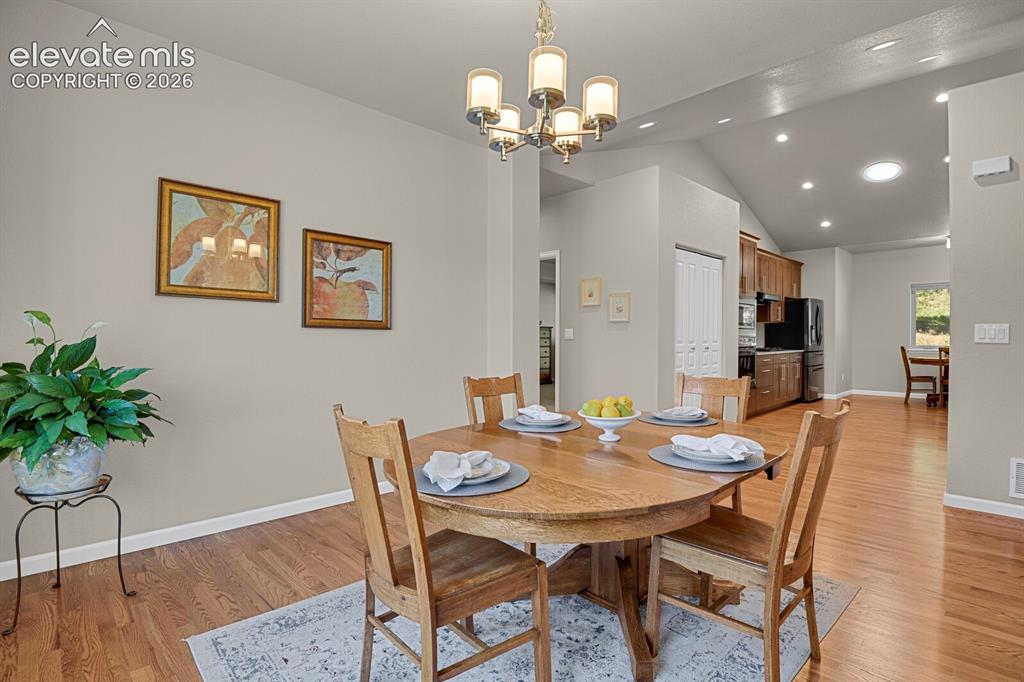 Image 18 of 46: Vaulted ceilings, wood-finish flooring, recessed lighting, and a multi-arm 