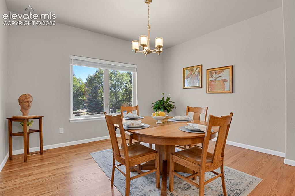 Image 19 of 46: Dining area featuring wood-finish flooring, a large picture window, and a m